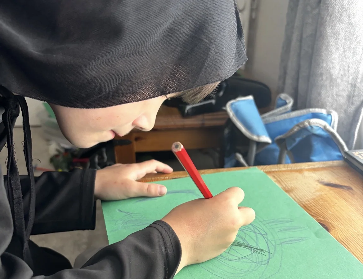 A young Creator sketching an idea on paper as part of shaping a world and story