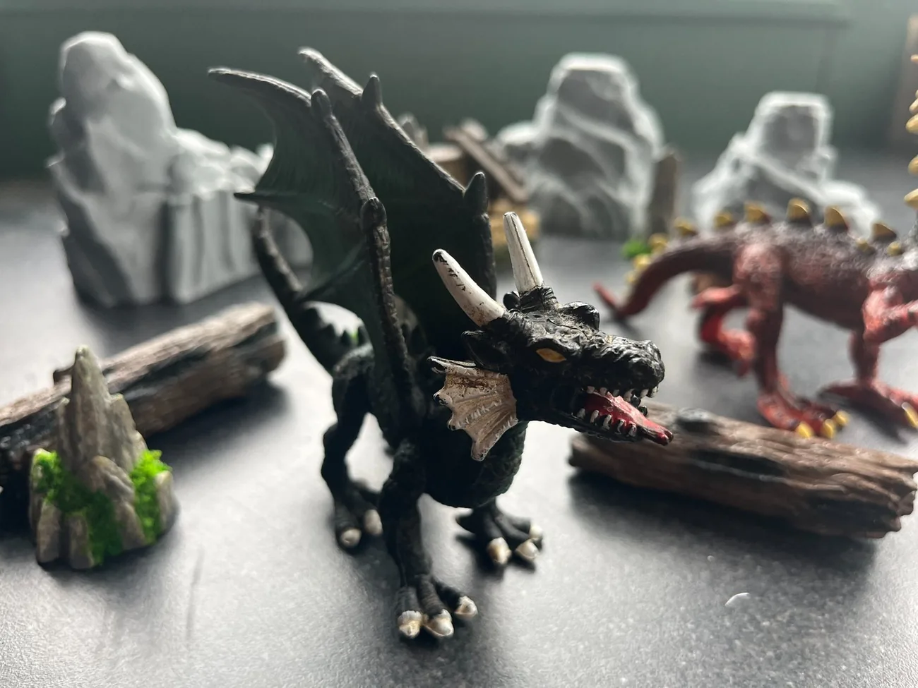 A painted dragon miniature among tabletop terrain during an encounter