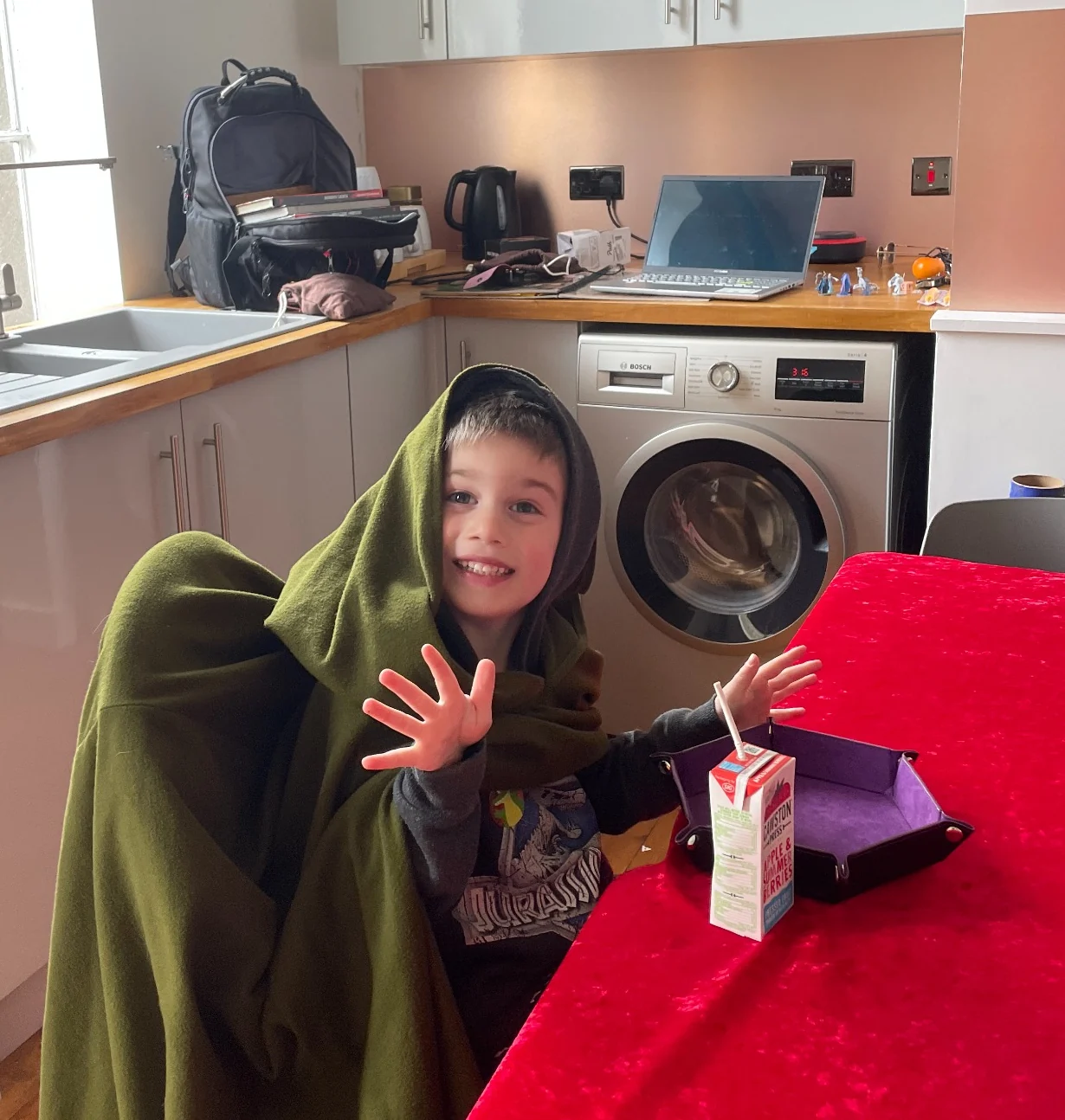 A wider view of the same young participant at the tabletop in costume, showing the player and play space together
